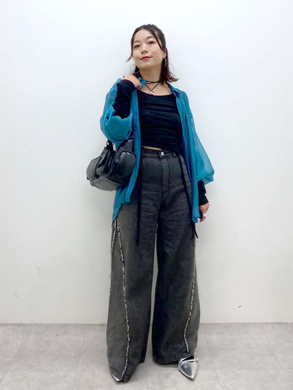 シルバー系のパンプス、ブラック系のデニムパンツ、ブラック系のショルダーバッグを着用したレディースの夏コーディネートの4枚目の写真