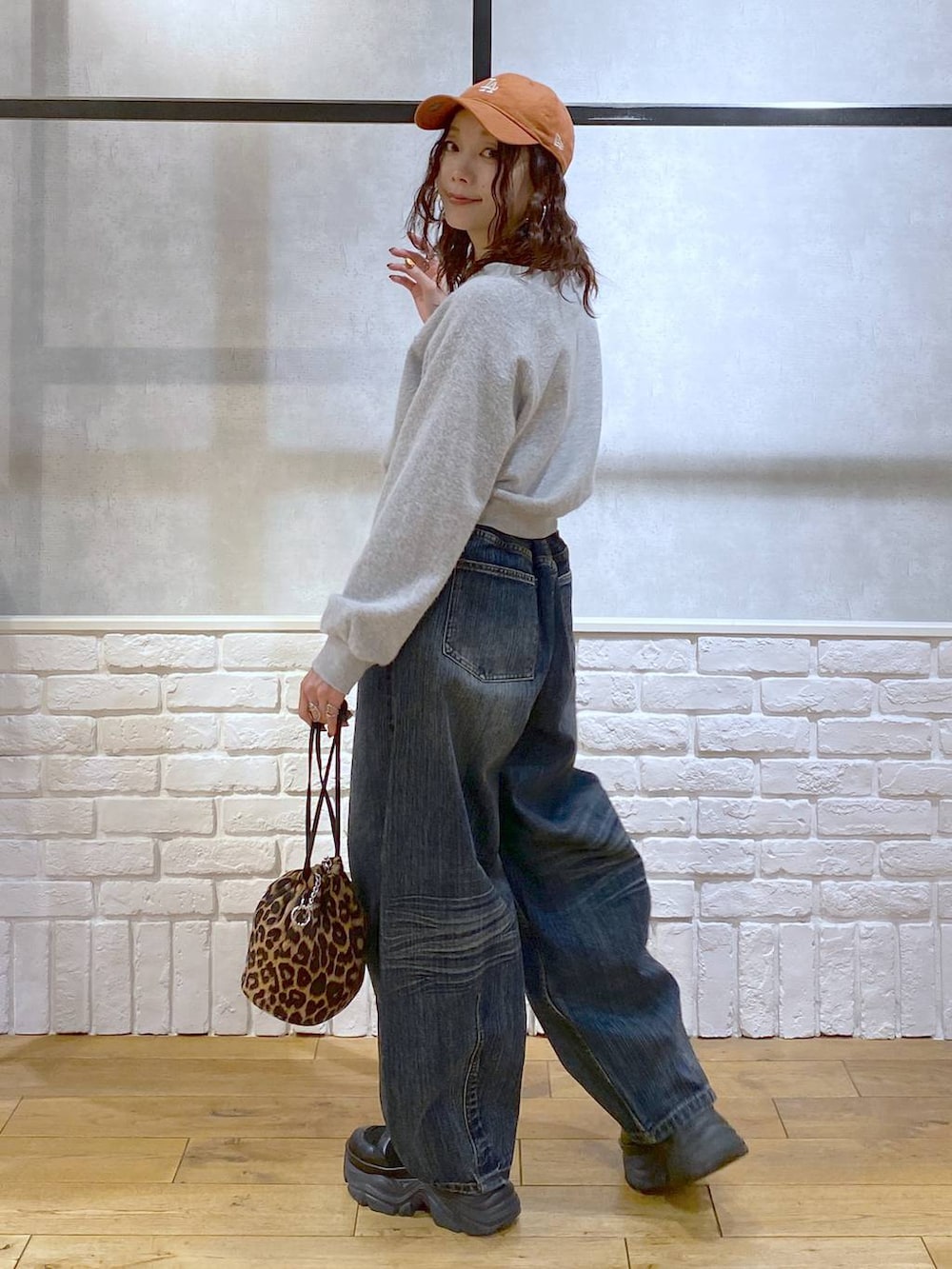 ブラック系のブーツ、ブルー系のデニムパンツ、その他のハンドバッグを着用したレディースの冬コーディネートの5枚目の写真