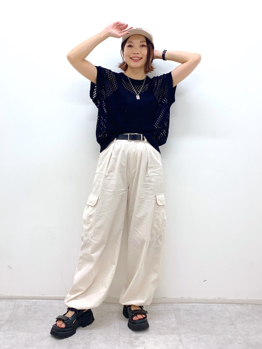 ホワイト系のカーゴパンツ、ブラック系のトップス、ブラック系のサンダルを着用したレディースの夏コーディネートの5枚目の写真