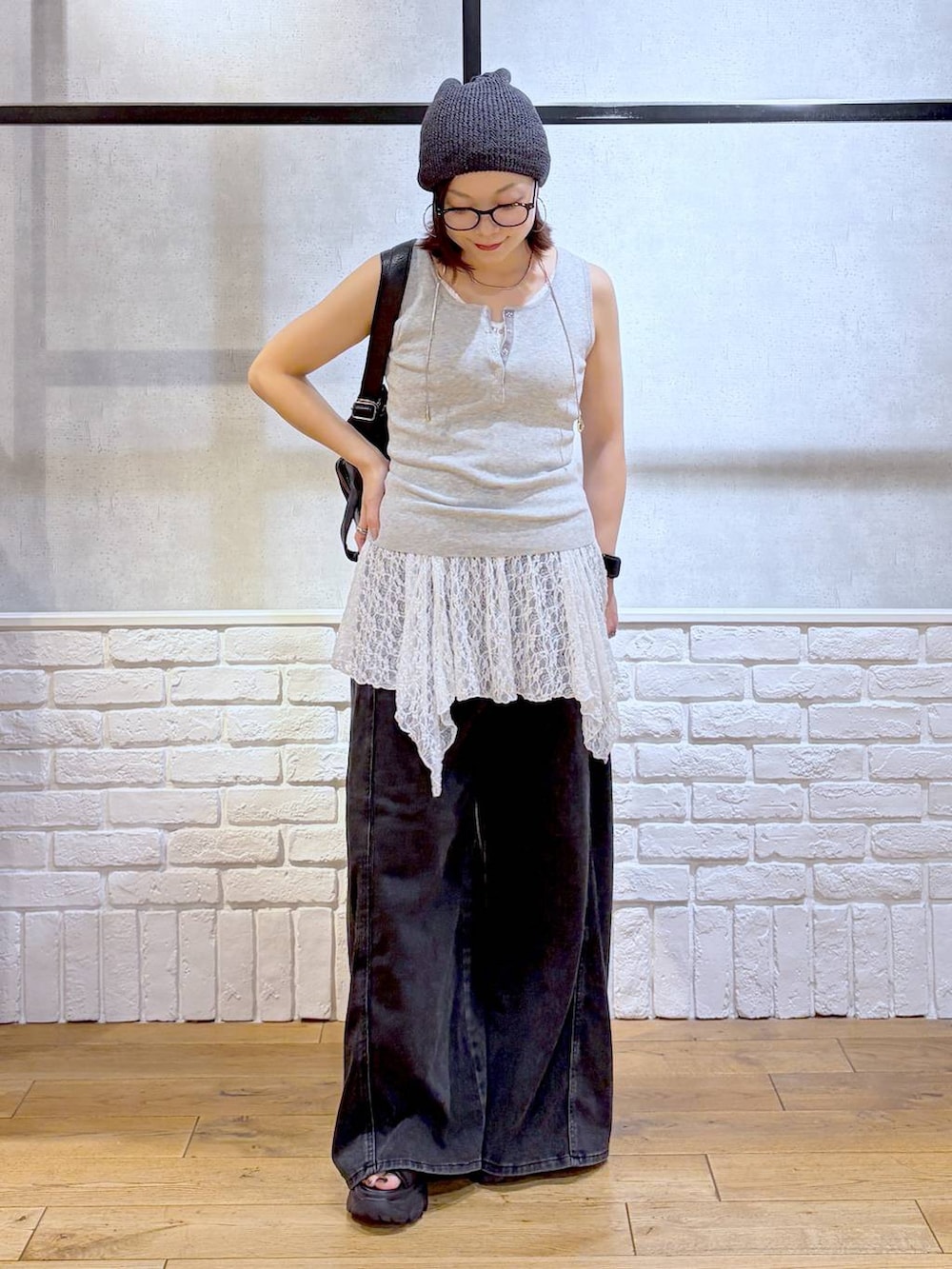ブラック系のデニムパンツ、ブラック系のショルダーバッグ、ブラック系のサンダルを着用したレディースの夏コーディネートの8枚目の写真