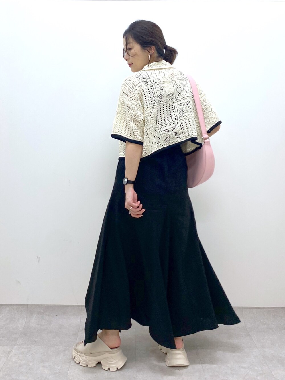 ブラック系のスカート、ホワイト系のカーディガン/ボレロ、ピンク系のショルダーバッグを着用したレディースの夏コーディネートの4枚目の写真