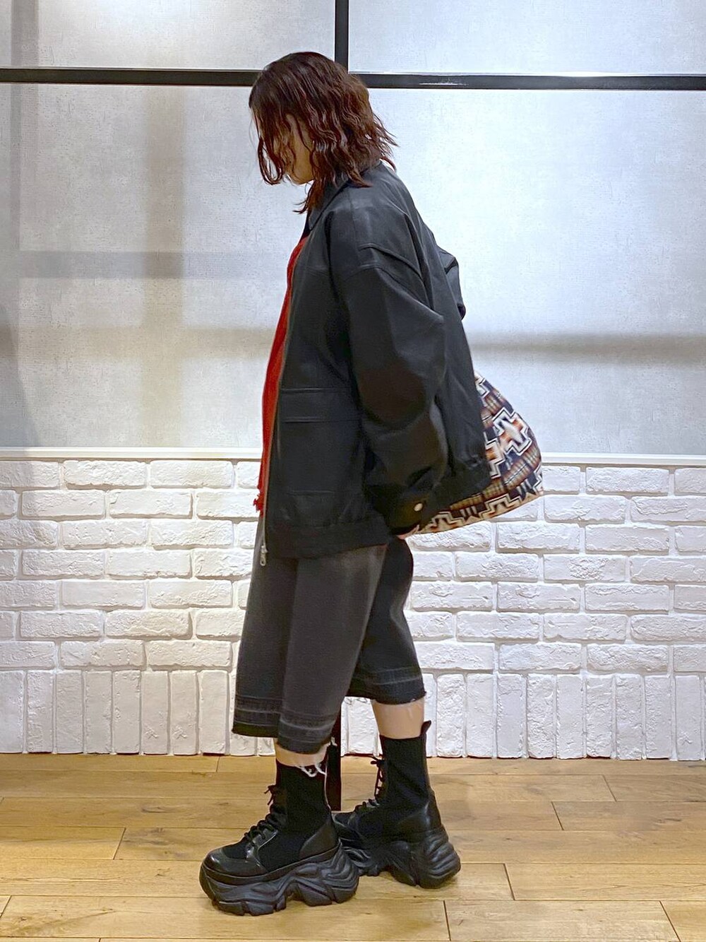 ブラック系のブーツ、ブラック系のデニムパンツ、ブラック系のブルゾンを着用したレディースの秋コーディネートの6枚目の写真