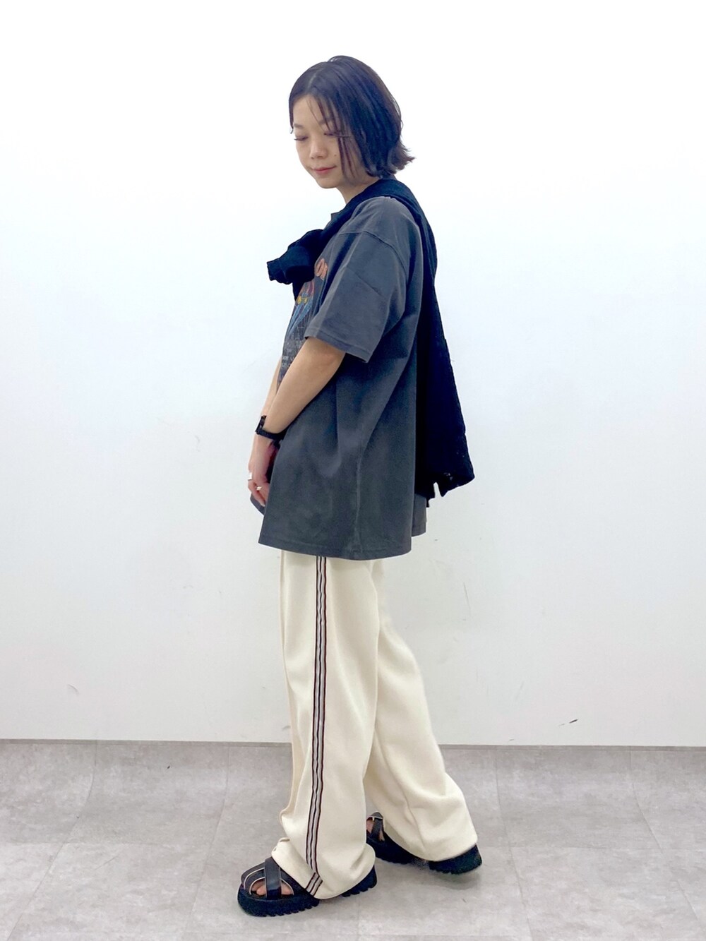 グレー系のTシャツ/カットソー、ブラック系のサンダル、ホワイト系のその他パンツを着用したレディースの春コーディネートの4枚目の写真