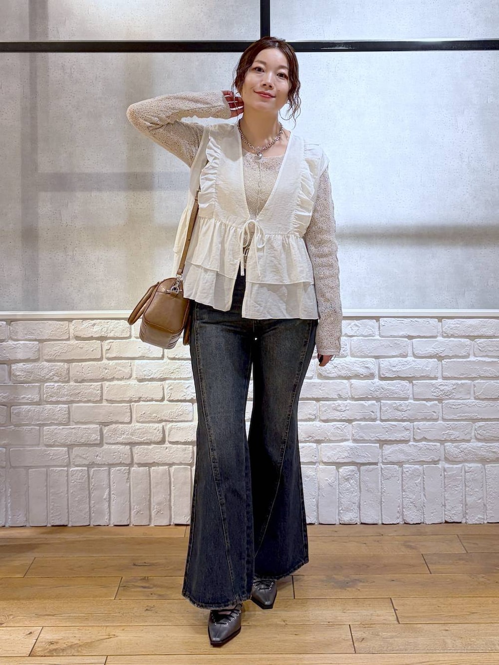 ブルー系のデニムパンツ、ブラウン系のボストンバッグ、ブラウン系のサンダルを着用したレディースの春コーディネートの9枚目の写真