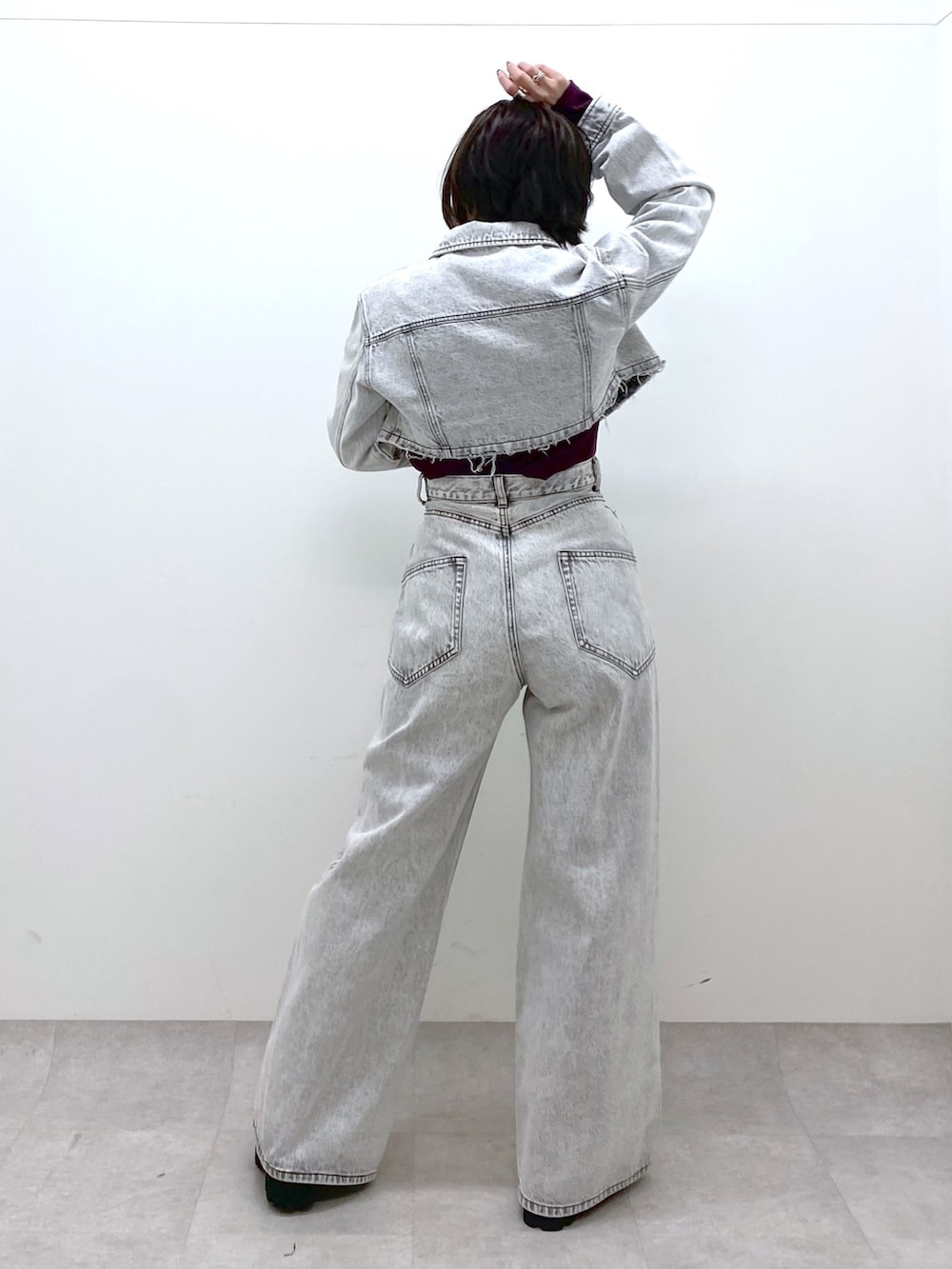 グレー系のデニムパンツ、グレー系のデニムジャケット、レッド系のTシャツ/カットソーを着用したレディースの冬コーディネートの3枚目の写真