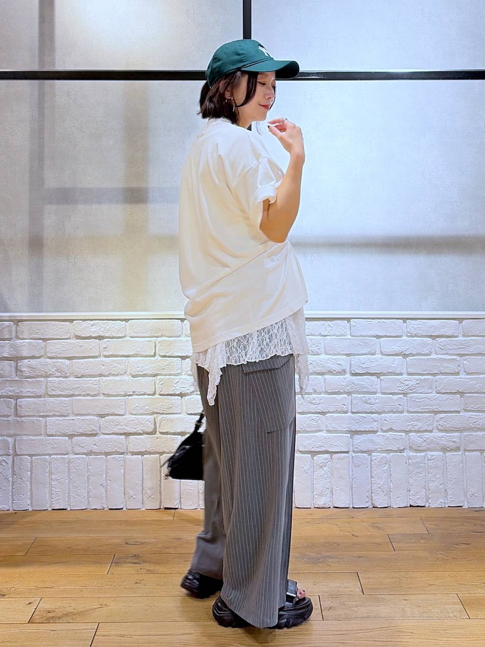 ブラック系のサンダル、ホワイト系のTシャツ/カットソー、ブラック系のトートバッグを着用したレディースの夏コーディネートの5枚目の写真