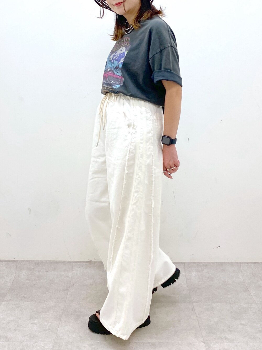 ホワイト系のデニムパンツ、ブラック系のショルダーバッグ、グレー系のTシャツ/カットソーを着用したレディースの春コーディネートの3枚目の写真