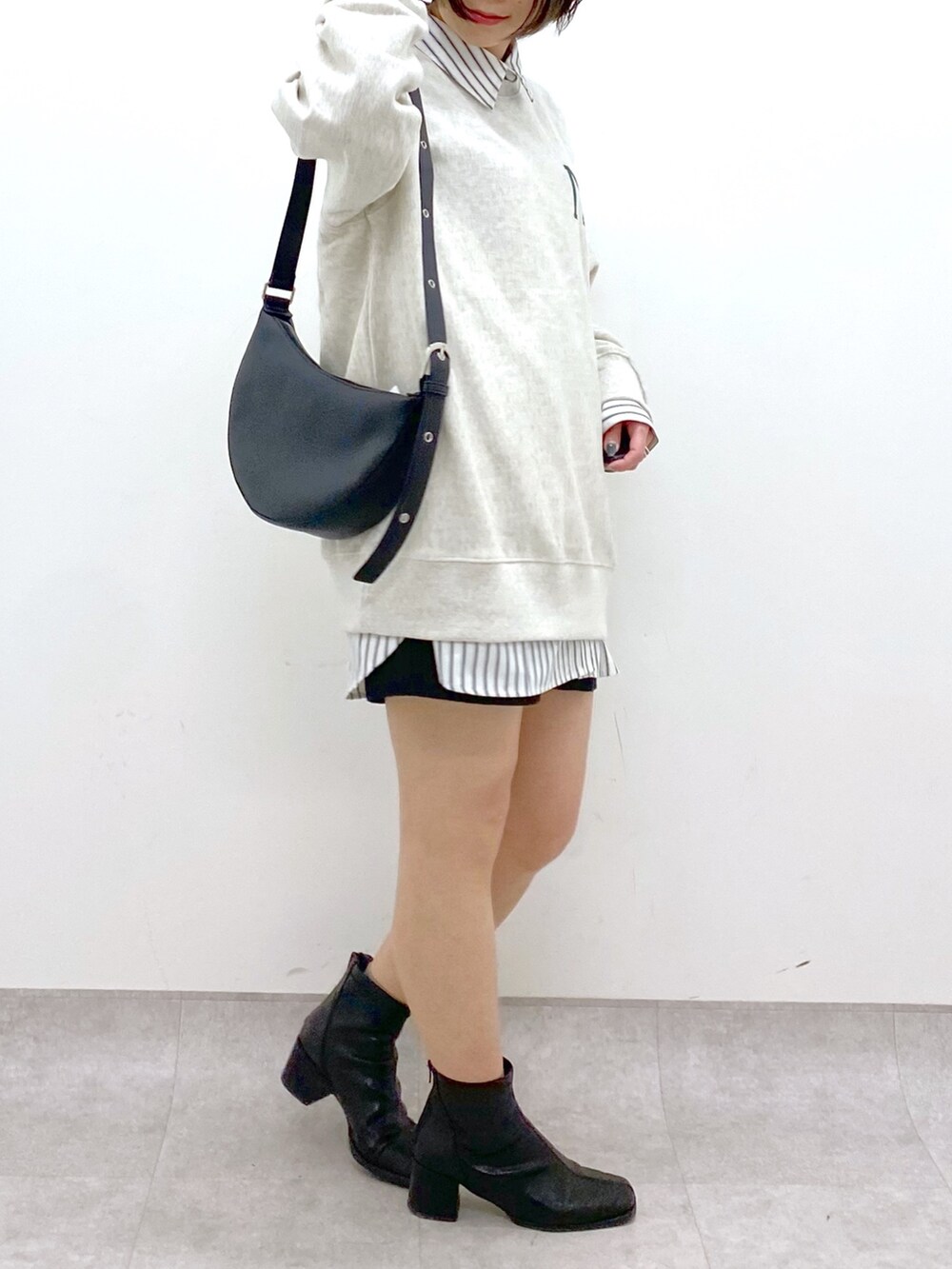 ブラック系のショルダーバッグ、ブラック系のシューズ、ベージュ系のトップスを着用したレディースの冬コーディネートの4枚目の写真