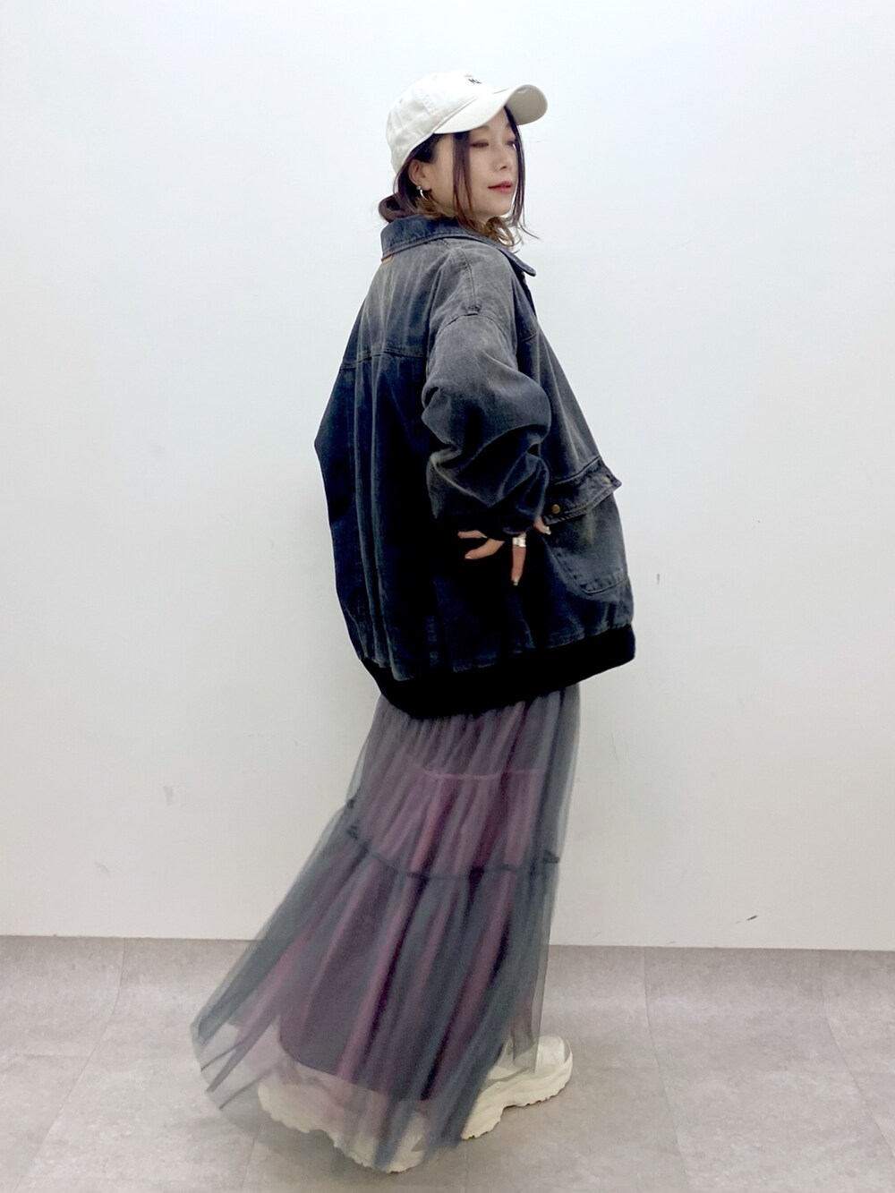 ホワイト系のTシャツ/カットソー、ブラック系のデニムジャケット、グレー系のスカートを着用したレディースの冬コーディネートの7枚目の写真