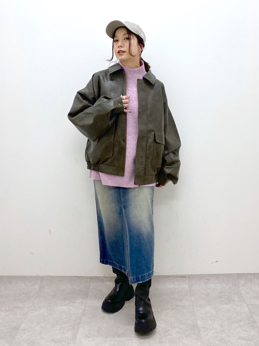 レッド系のニット/セーター、ブルー系のスカート、ブラック系のブーツを着用したレディースの秋コーディネートの8枚目の写真