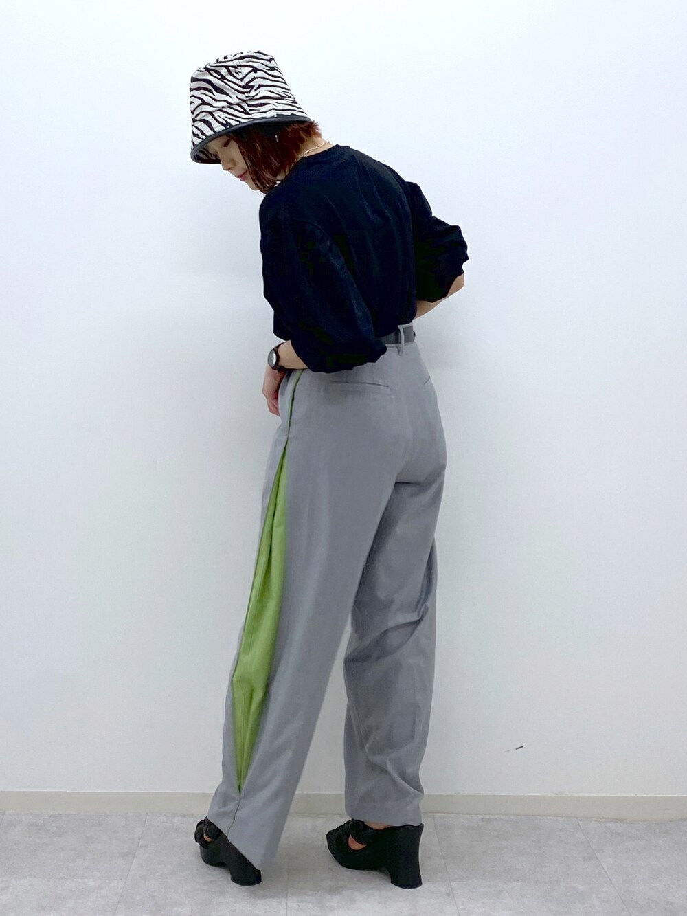 ブラック系のTシャツ/カットソー、グレー系のスラックス、ブラック系のサンダルを着用したレディースの春コーディネートの3枚目の写真