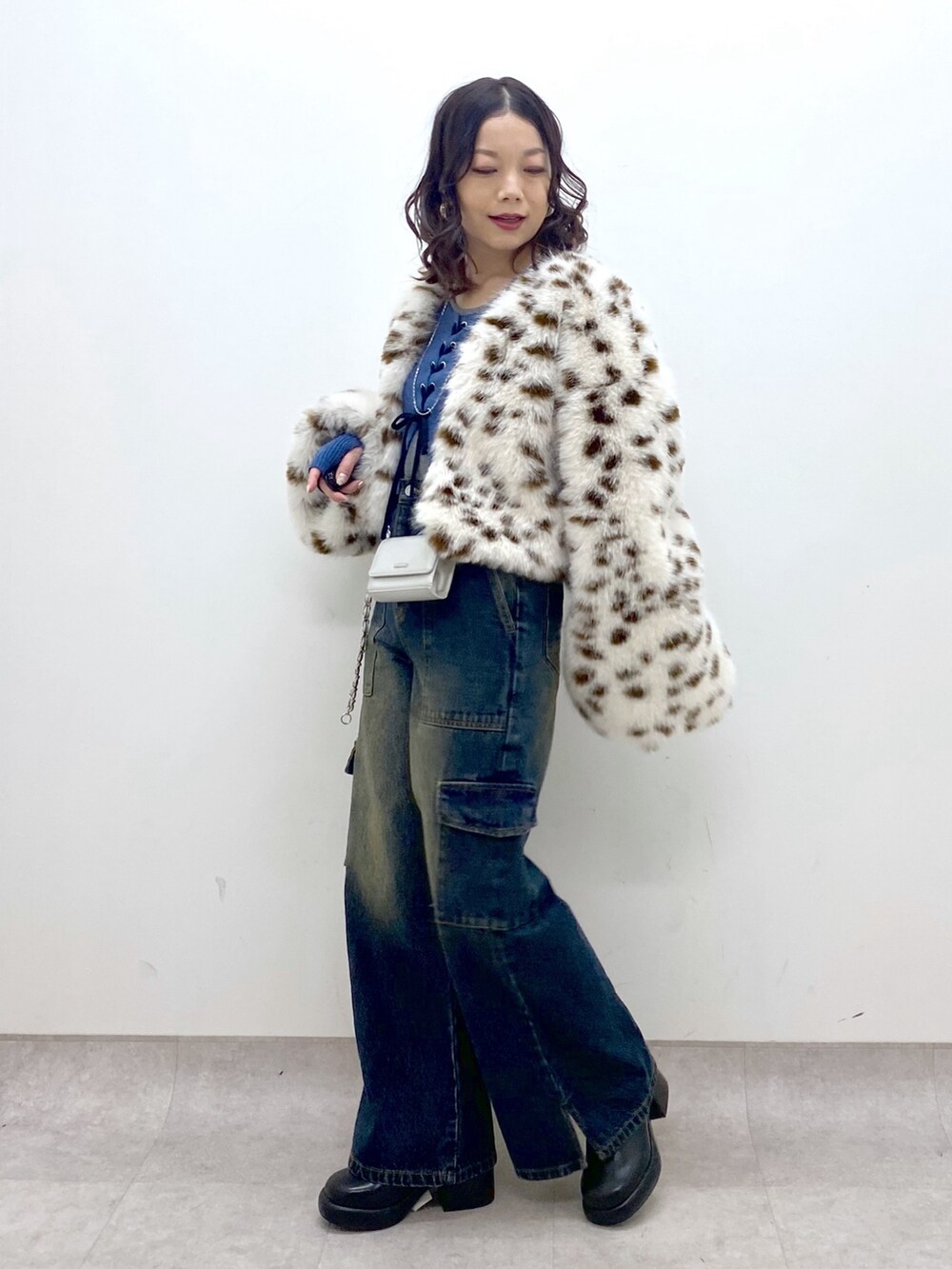 ブルー系のデニムパンツ、ブルー系のニット/セーター、ブラック系のブーツを着用したレディースの冬コーディネートの2枚目の写真