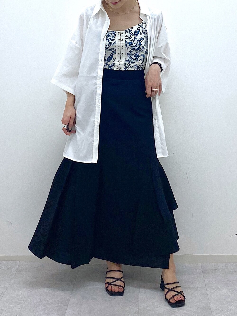 ブラック系のスカート、ブラック系のサンダル、ホワイト系のシャツ/ブラウスを着用したレディースの夏コーディネートの5枚目の写真