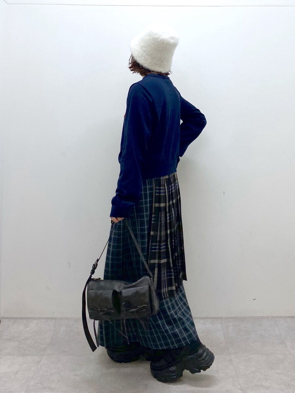 ブルー系のニット/セーター、ブルー系のスカート、ブラック系のショルダーバッグを着用したレディースの秋コーディネートの7枚目の写真