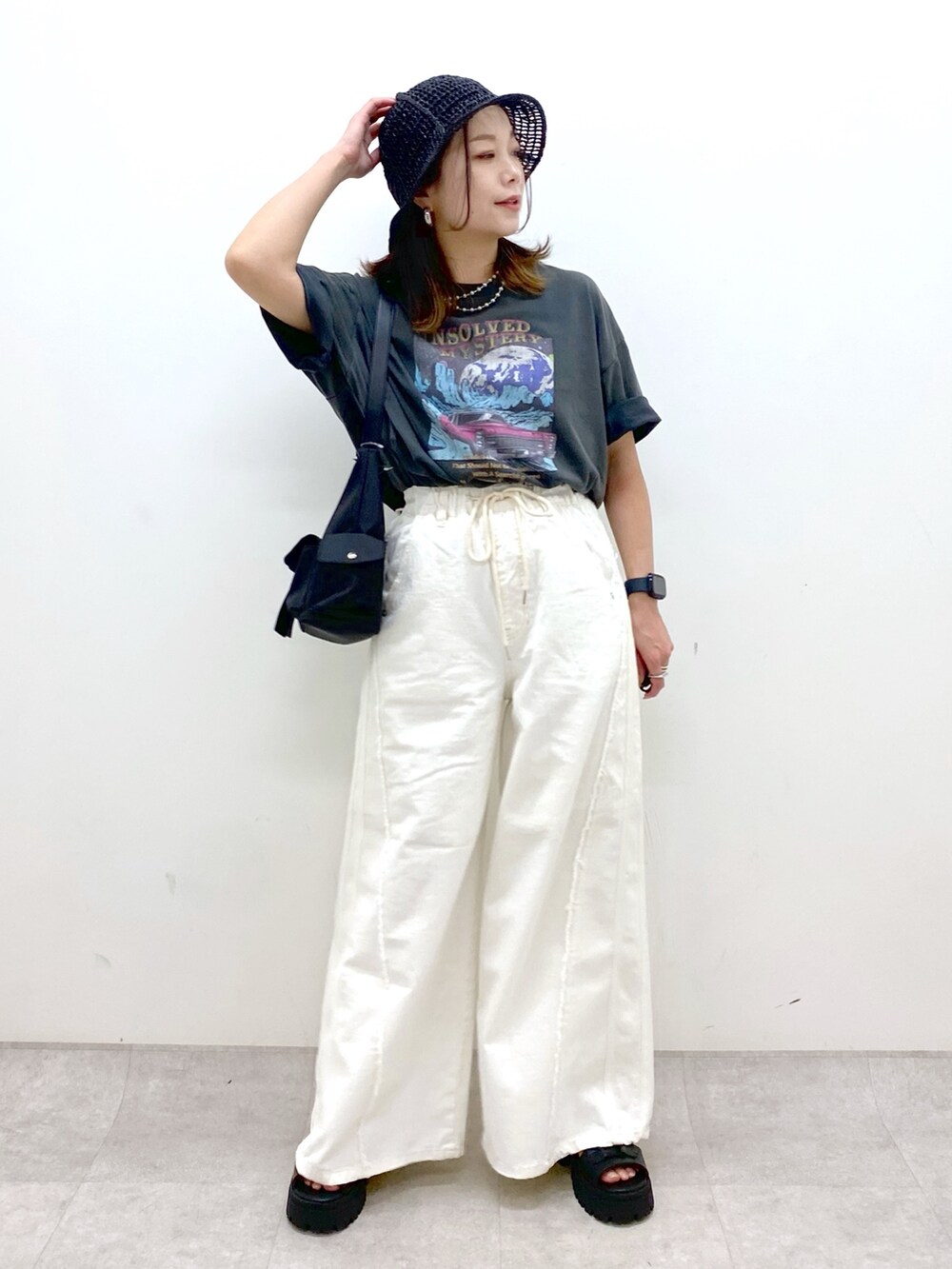 ホワイト系のデニムパンツ、ブラック系のショルダーバッグ、グレー系のTシャツ/カットソーを着用したレディースの春コーディネートの8枚目の写真