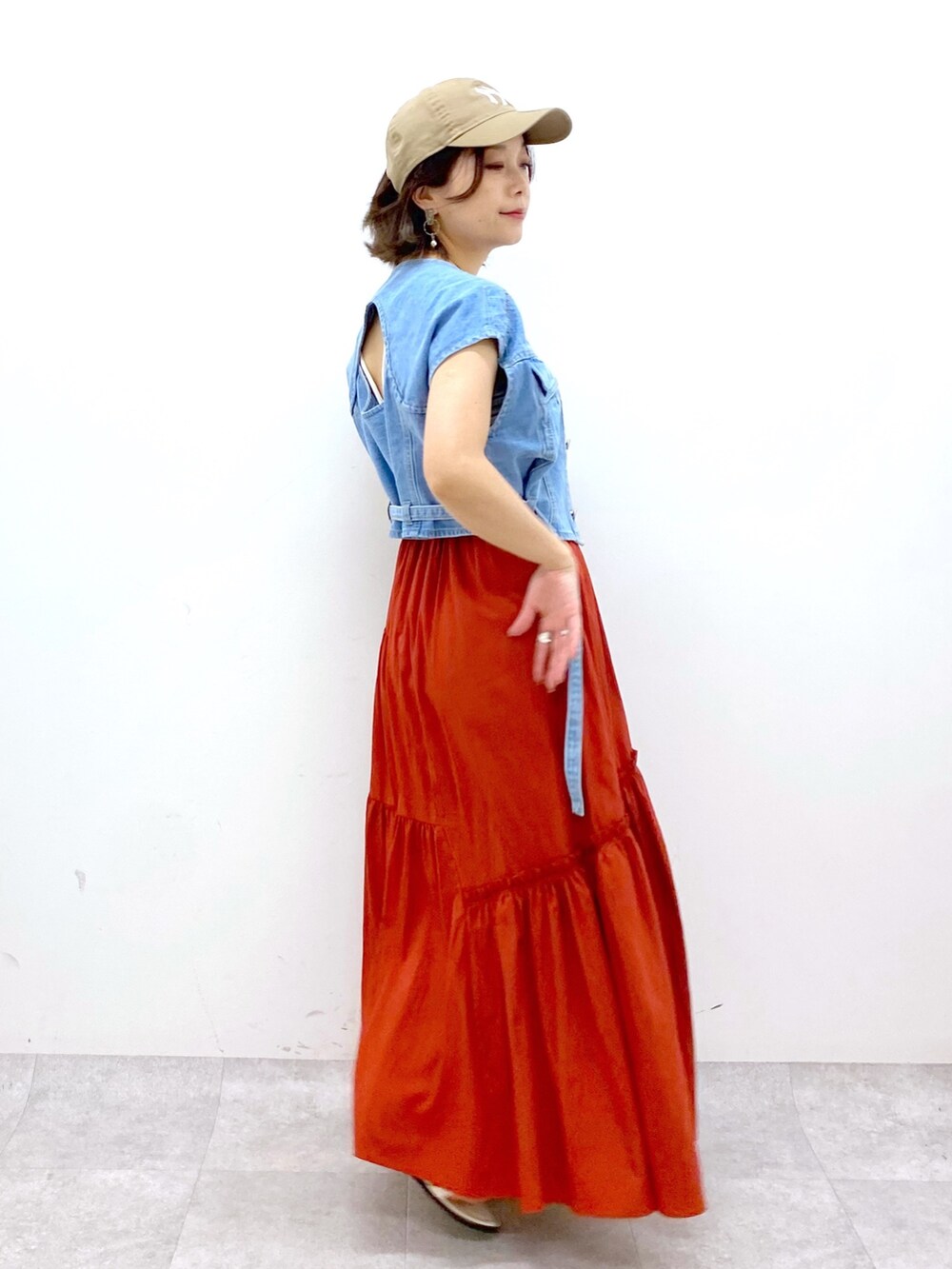 オレンジ系のスカート、ブルー系のその他アウター、ブラック系のキャミソールを着用したレディースの夏コーディネートの3枚目の写真