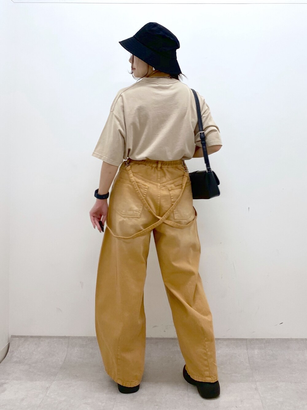 ベージュ系のTシャツ/カットソー、ベージュ系のデニムパンツ、ブラック系のサンダルを着用したレディースの春コーディネートの6枚目の写真