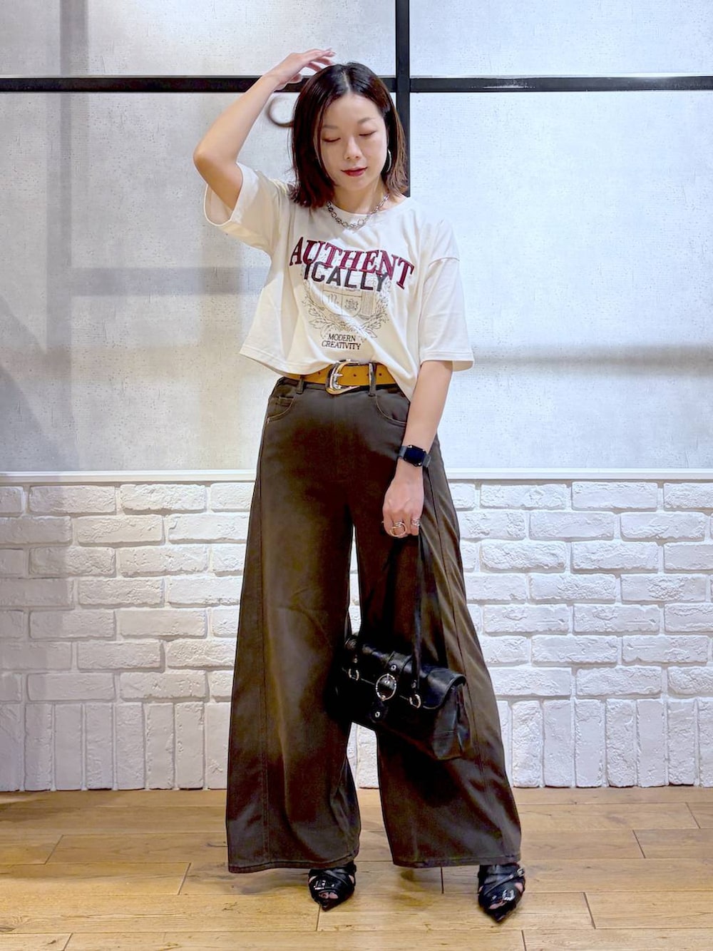 ブラウン系のデニムパンツ、ホワイト系のTシャツ/カットソー、ブラック系のサンダルを着用したレディースの夏コーディネートの9枚目の写真