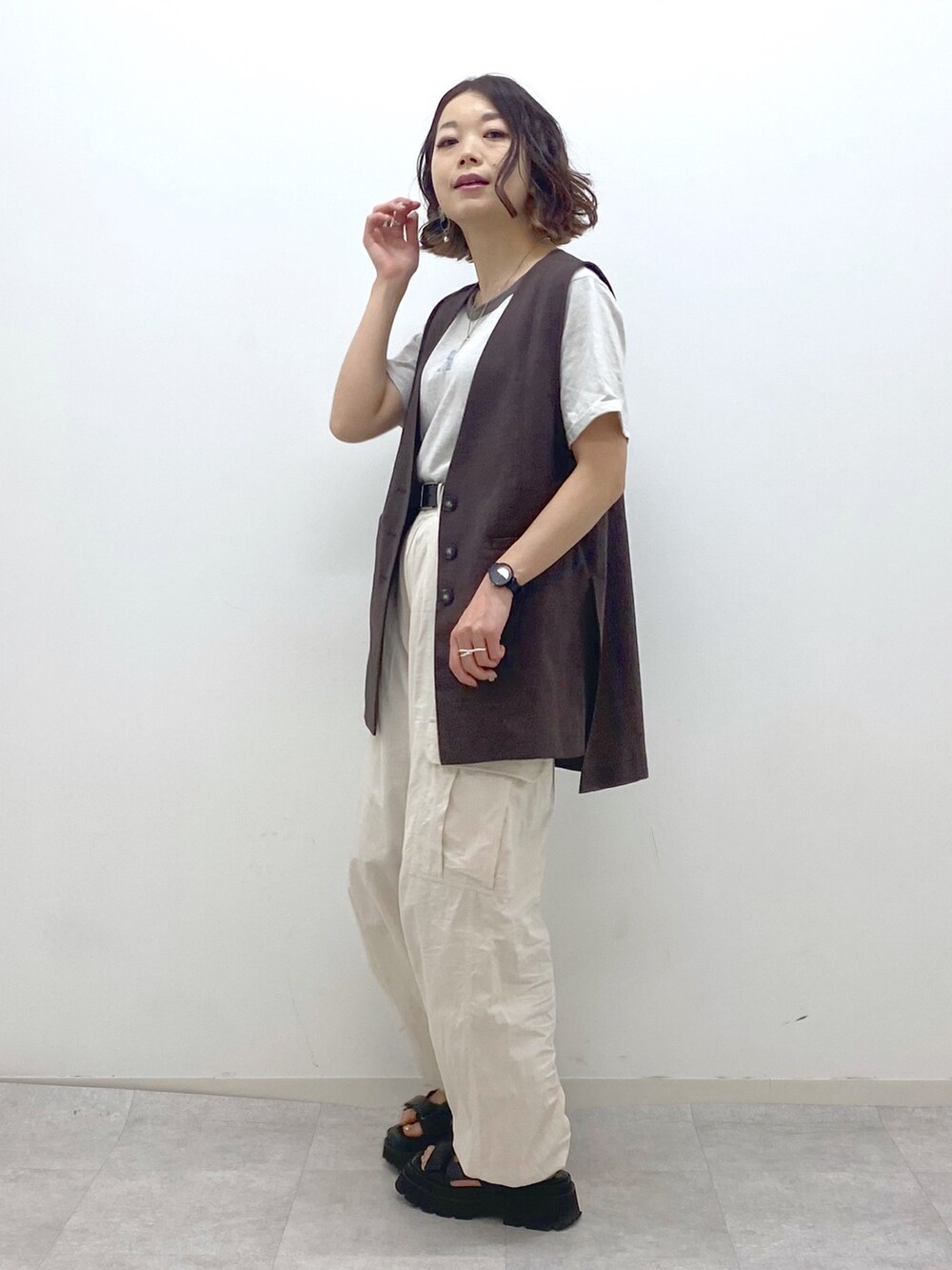 ホワイト系のカーゴパンツ、ブラック系のサンダル、ベージュ系のTシャツ/カットソーを着用したレディースの夏コーディネートの2枚目の写真