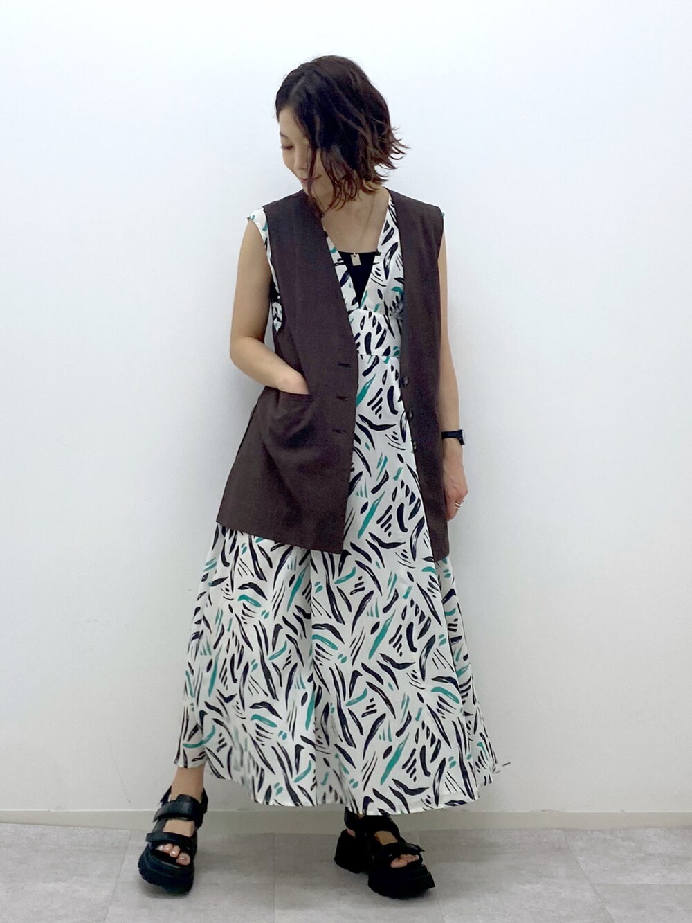 ホワイト系のワンピース、ブラウン系のその他アウター、ブラック系のサンダルを着用したレディースの夏コーディネートの2枚目の写真