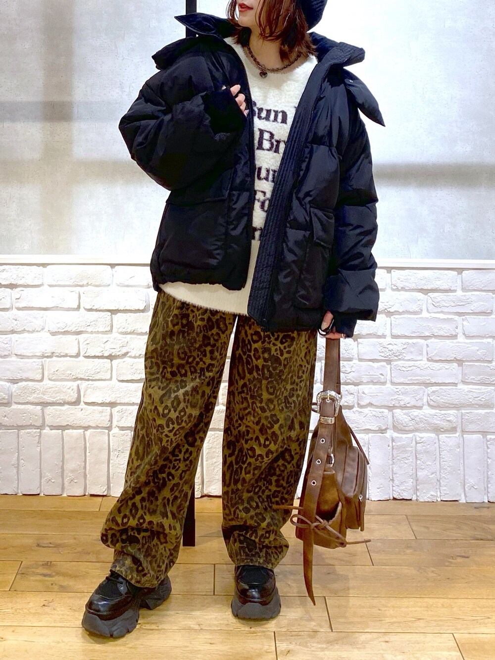 ホワイト系のニット/セーター、ブラック系のブルゾン、その他のデニムパンツを着用したレディースの冬コーディネートの2枚目の写真