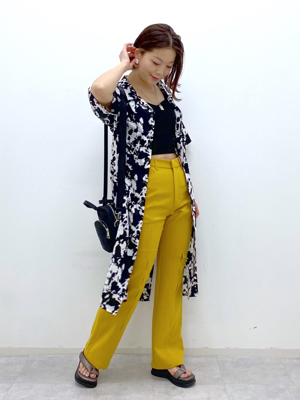 イエロー系のスラックス、その他のサンダル、ブラック系のショルダーバッグを着用したレディースの春コーディネートの5枚目の写真