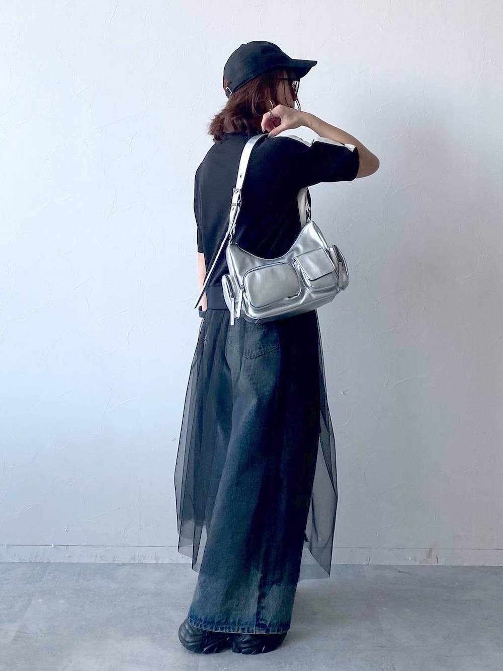 ブラック系のスニーカー、シルバー系のショルダーバッグ、ブルー系のデニムパンツを着用したレディースの夏コーディネートの7枚目の写真