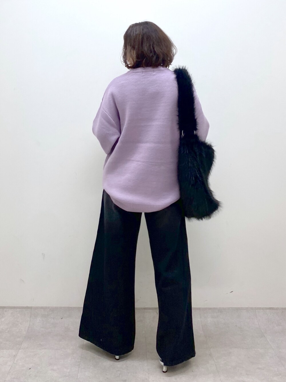 パープル系のニット/セーター、ブラック系のデニムパンツ、シルバー系のパンプスを着用したレディースの秋コーディネートの5枚目の写真