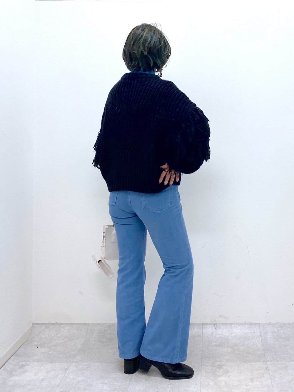 ブルー系のパンツ、ホワイト系のバッグ、ブラック系のシューズを着用したレディースの秋コーディネートの2枚目の写真