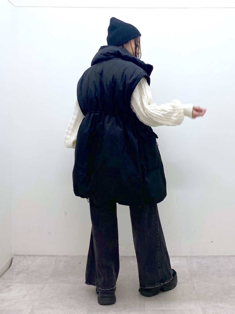 ブラック系のブルゾン、ホワイト系のニット/セーター、ブラック系のデニムパンツを着用したレディースの冬コーディネートの4枚目の写真