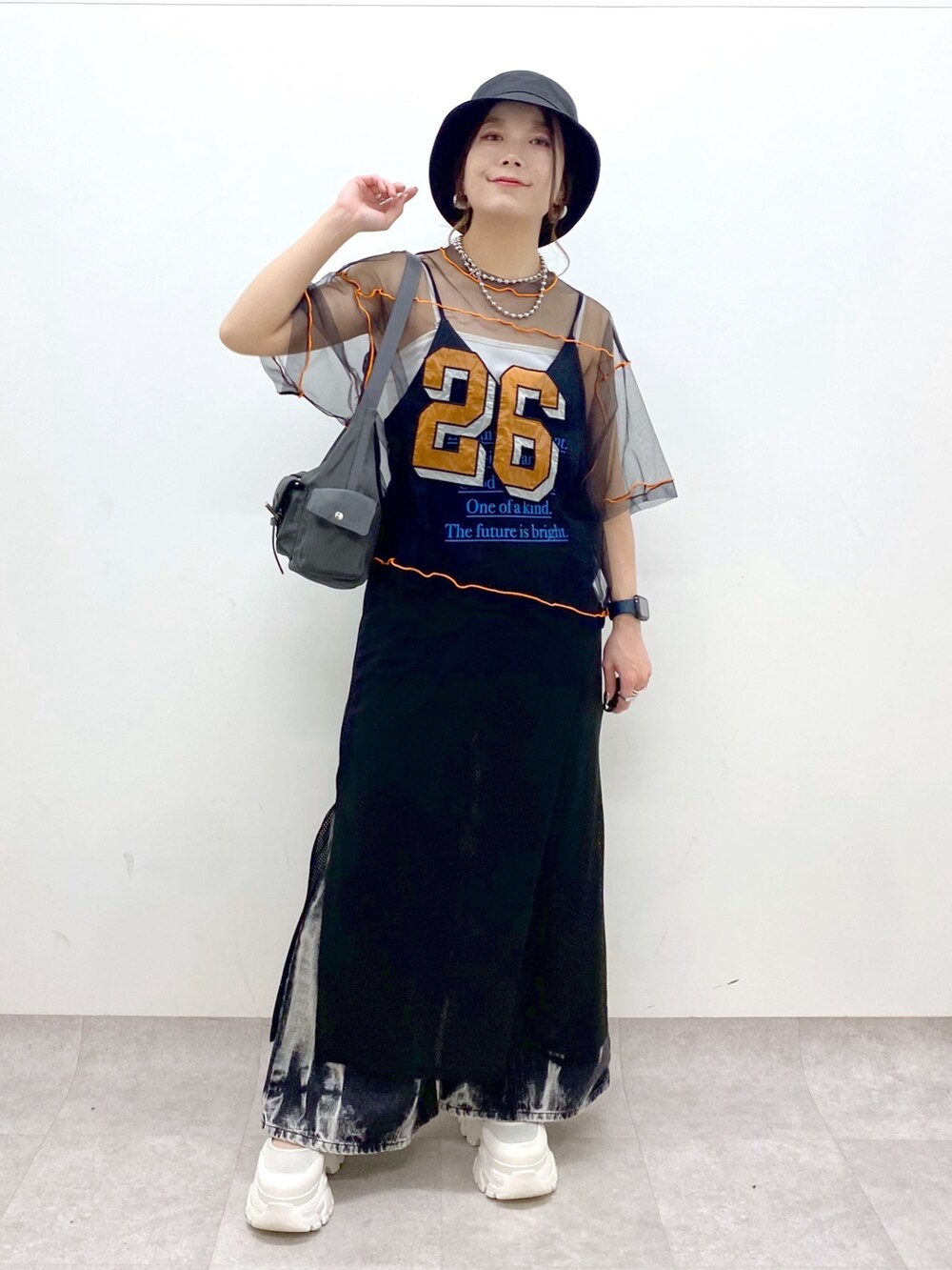 グレー系のショルダーバッグ、ホワイト系のスニーカー、ブラック系のデニムパンツを着用したレディースの春コーディネートの9枚目の写真