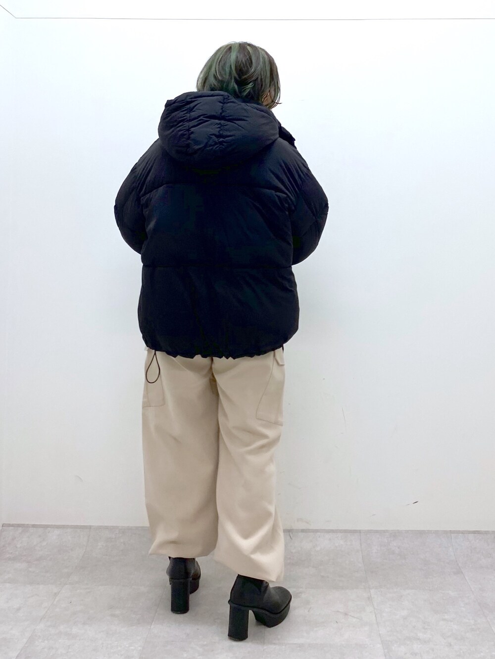 ブラック系のジャケット/アウター、ホワイト系のニット/セーター、ベージュ系のカーゴパンツを着用したレディースの冬コーディネートの3枚目の写真