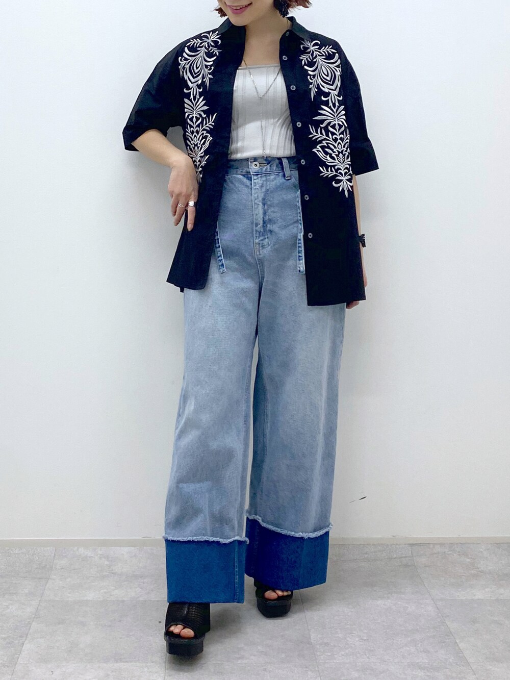 ブルー系のデニムパンツ、ブラック系のシャツ/ブラウス、ベージュ系のタンクトップを着用したレディースの春コーディネートの5枚目の写真