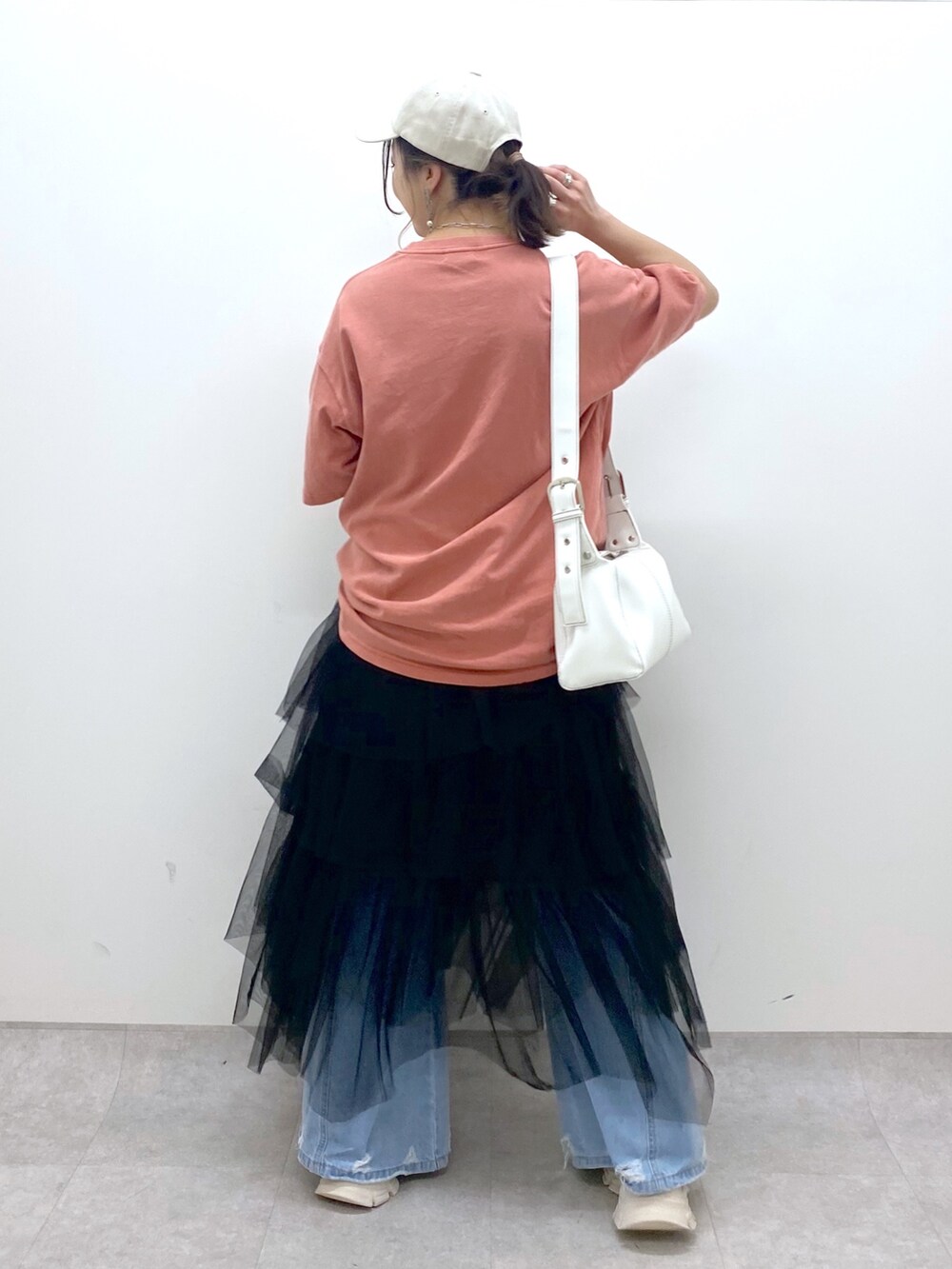 ブルー系のデニムパンツ、オレンジ系のTシャツ/カットソー、ブラック系のスカートを着用したレディースの夏コーディネートの4枚目の写真