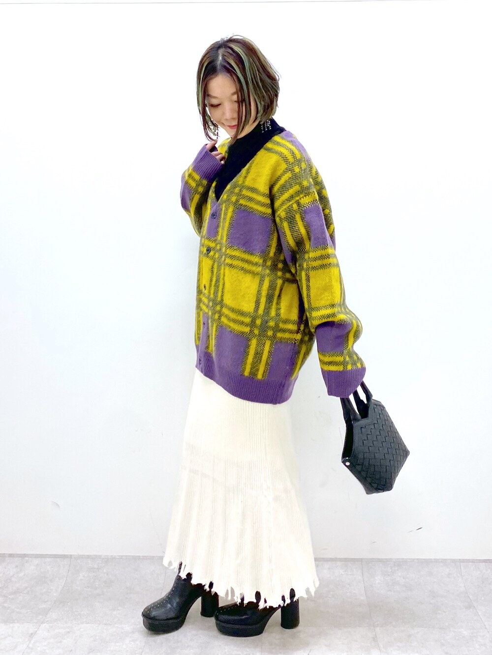 ホワイト系のトップス、ゴールド系のスカート、ブラック系のブーツを着用したレディースの冬コーディネートの2枚目の写真