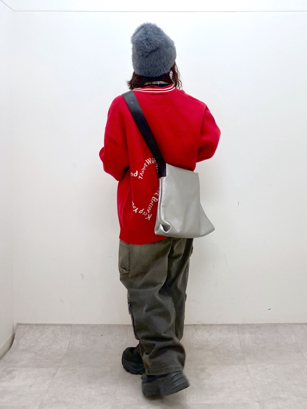 ブラック系のデニムパンツ、ブラック系のブーツ、シルバー系のトートバッグを着用したレディースの秋コーディネートの6枚目の写真