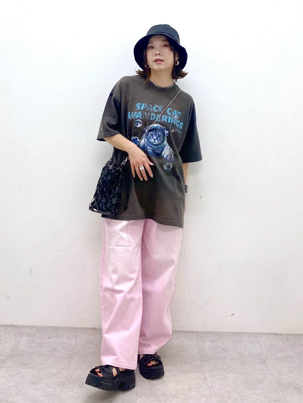 ピンク系のデニムパンツ、ブラック系のサンダル、ブラック系のショルダーバッグを着用したレディースの夏コーディネートの4枚目の写真