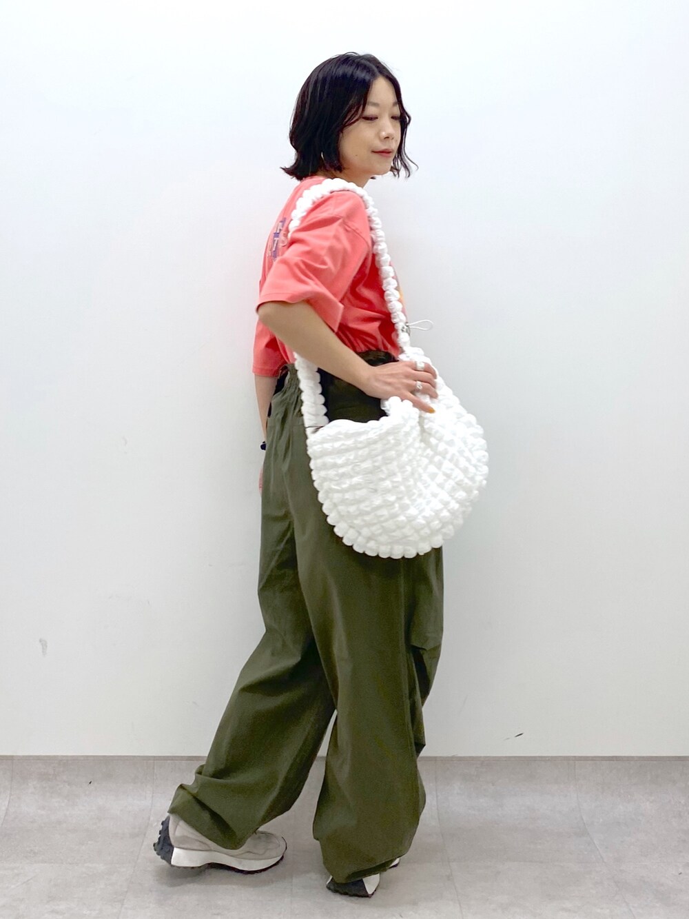 グリーン系のその他パンツ、ホワイト系のバッグ、レッド系のTシャツ/カットソーを着用したレディースの春コーディネートの2枚目の写真