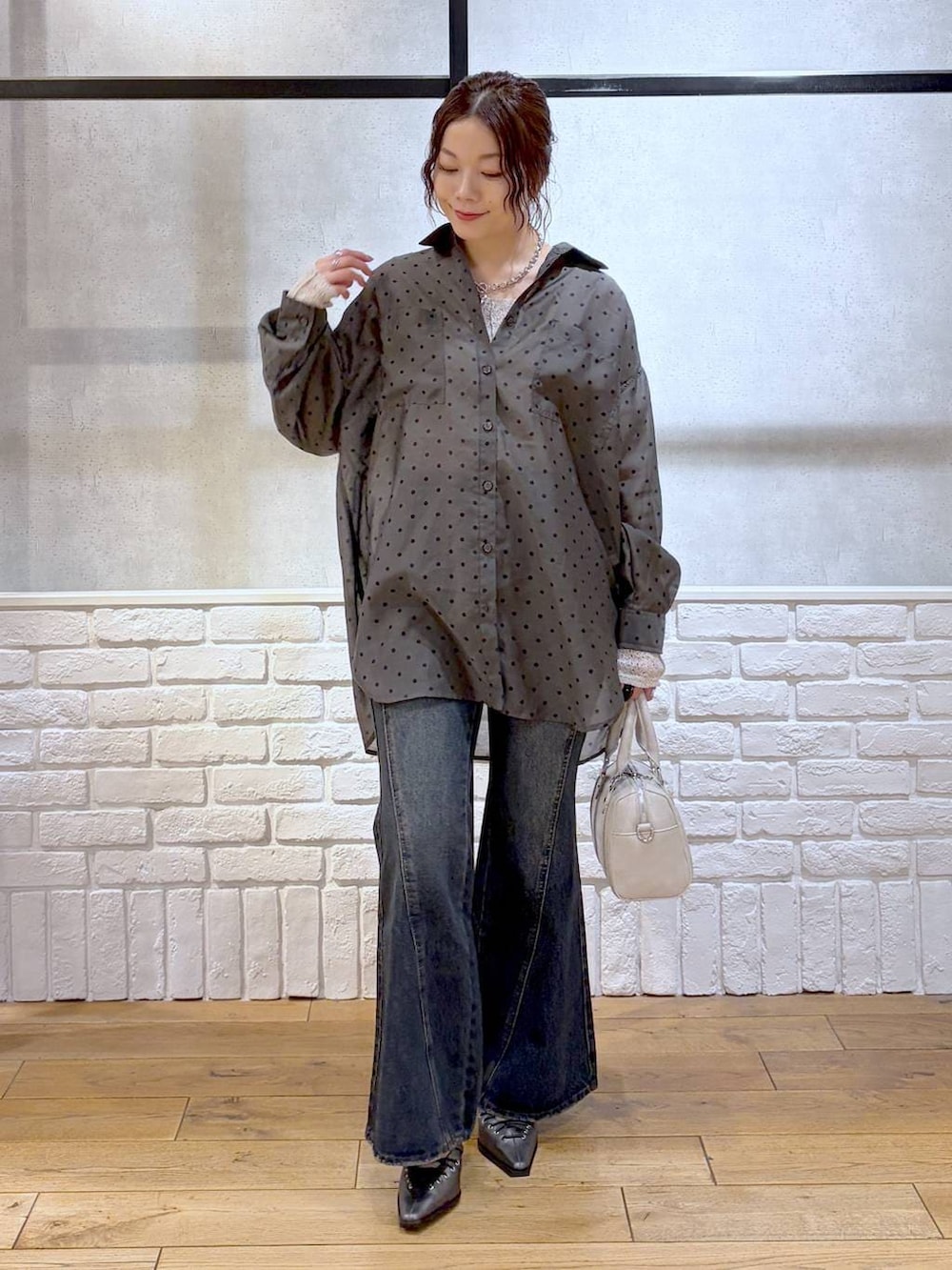 ブルー系のデニムパンツ、ホワイト系のボストンバッグ、ブラウン系のサンダルを着用したレディースの春コーディネートの9枚目の写真