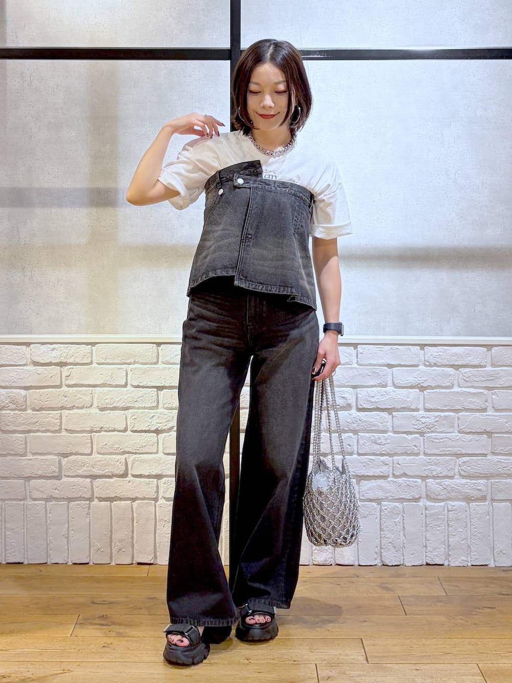 ブラック系のデニムパンツ、シルバー系のショルダーバッグ、ブラック系のサンダルを着用したレディースの夏コーディネートの2枚目の写真