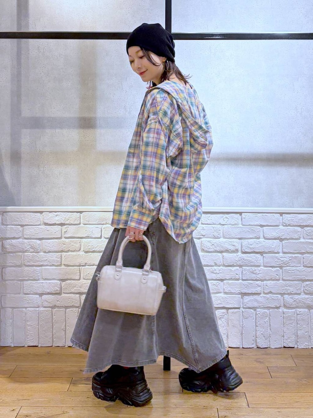 ブラック系のスニーカー、ホワイト系のボストンバッグ、ブラック系のワンピースを着用したレディースの春コーディネートの5枚目の写真