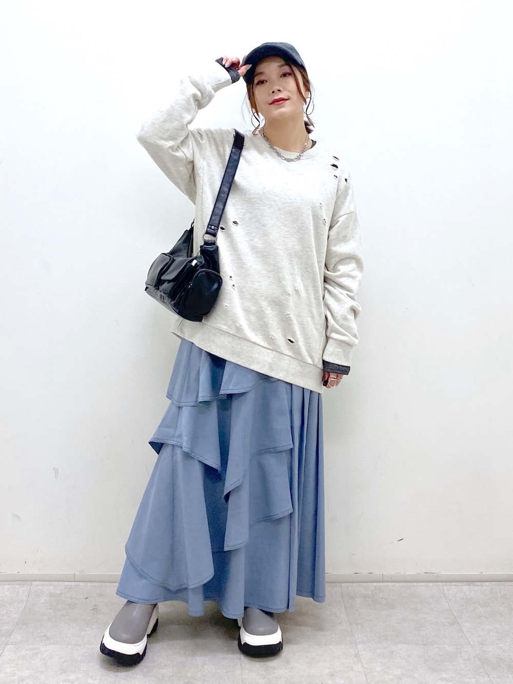 ブラック系のショルダーバッグ、ブルー系のスカート、グレー系のブーツを着用したレディースの秋コーディネートの5枚目の写真