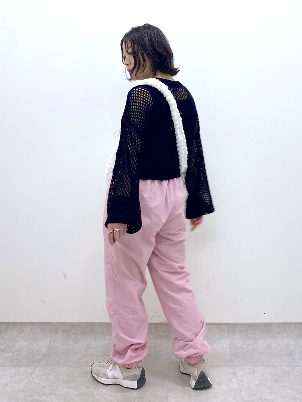 ホワイト系のバッグ、ピンク系のその他パンツ、ブラック系のニット/セーターを着用したレディースの春コーディネートの2枚目の写真