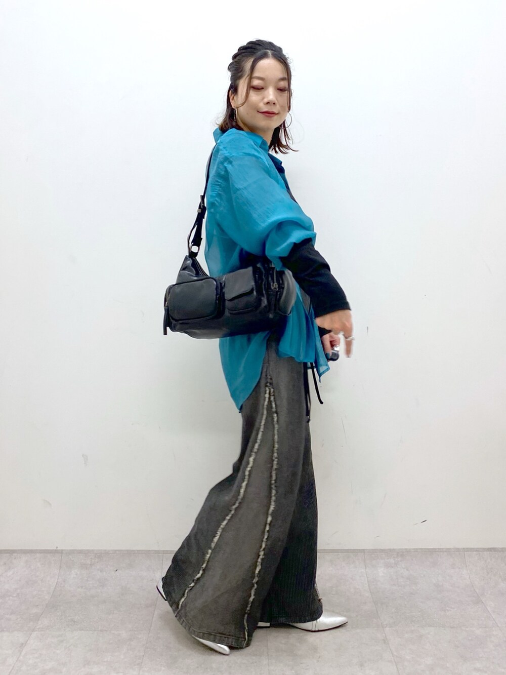 シルバー系のパンプス、ブラック系のデニムパンツ、ブラック系のショルダーバッグを着用したレディースの夏コーディネートの6枚目の写真