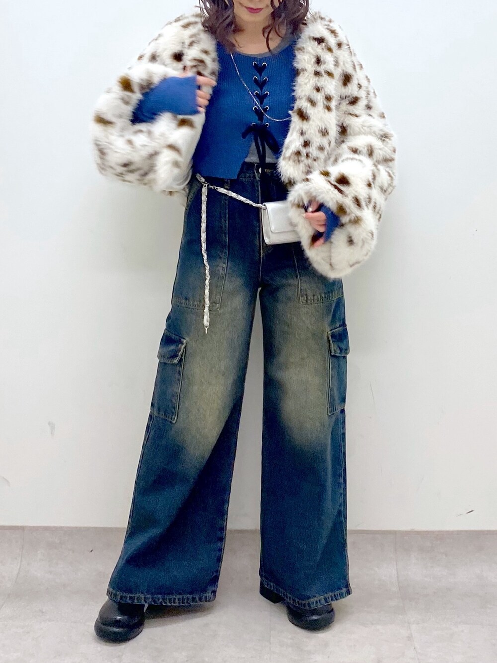 ブルー系のデニムパンツ、ブルー系のニット/セーター、ブラック系のブーツを着用したレディースの冬コーディネートの8枚目の写真