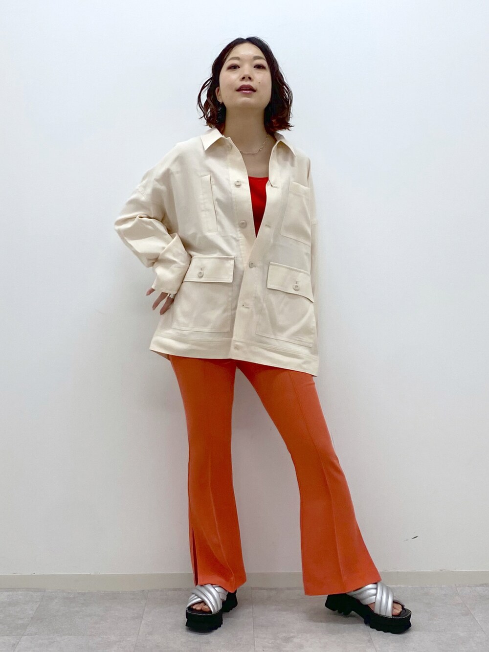 オレンジ系のその他パンツ、シルバー系のサンダル、ベージュ系のミリタリージャケットを着用したレディースの春コーディネートの5枚目の写真
