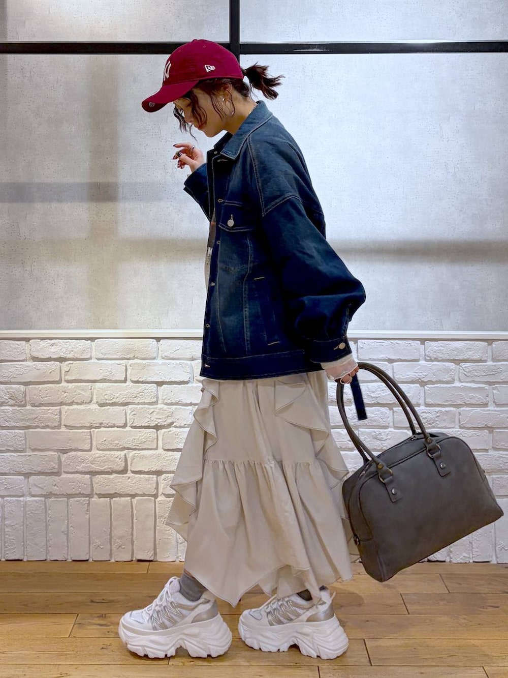 ホワイト系のスニーカー、グレー系のボストンバッグ、ベージュ系のスカートを着用したレディースの冬コーディネートの8枚目の写真