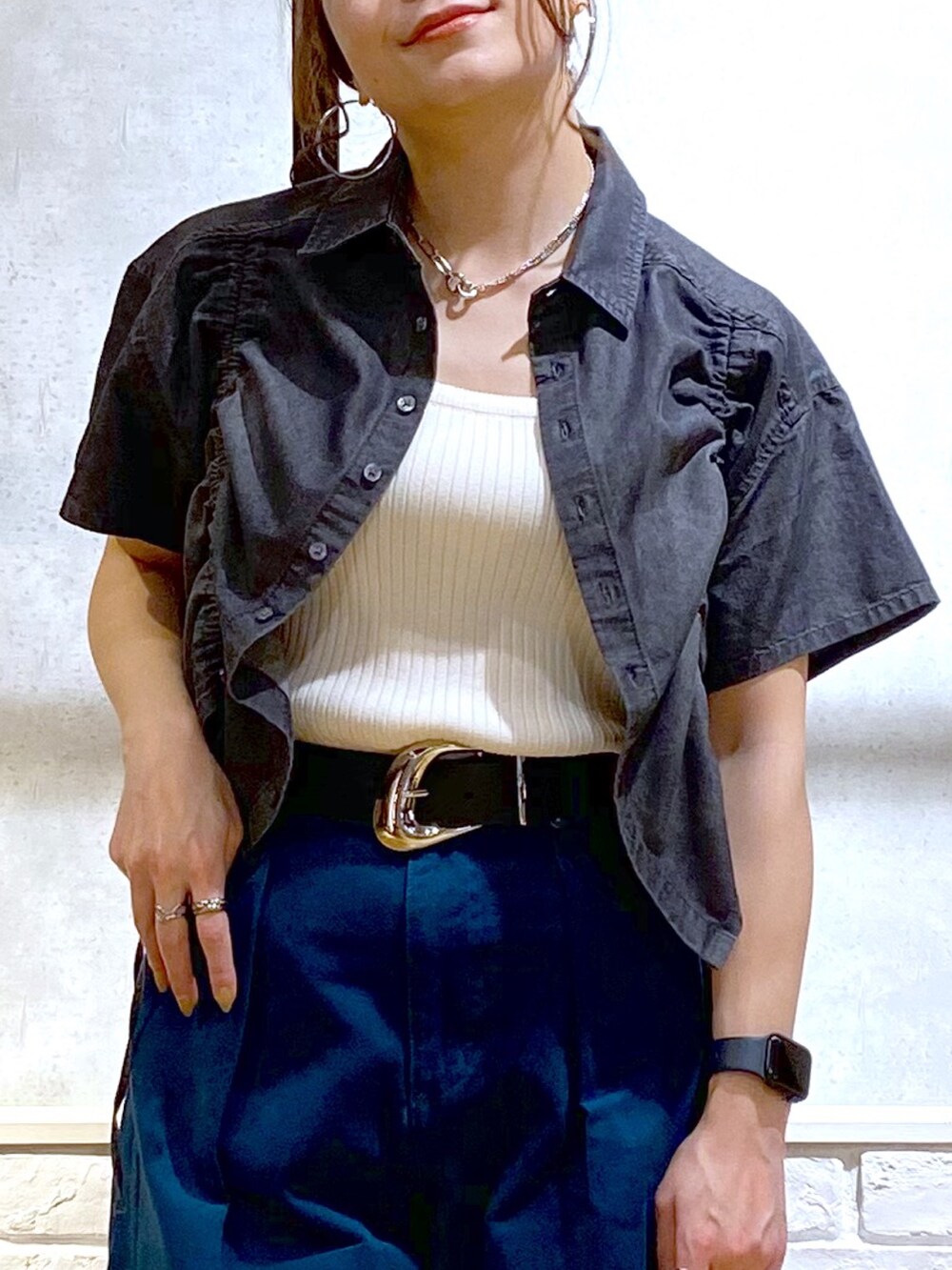 ホワイト系のタンクトップ、ブルー系のチノパンツ、ホワイト系のサンダルを着用したレディースの春コーディネートの2枚目の写真