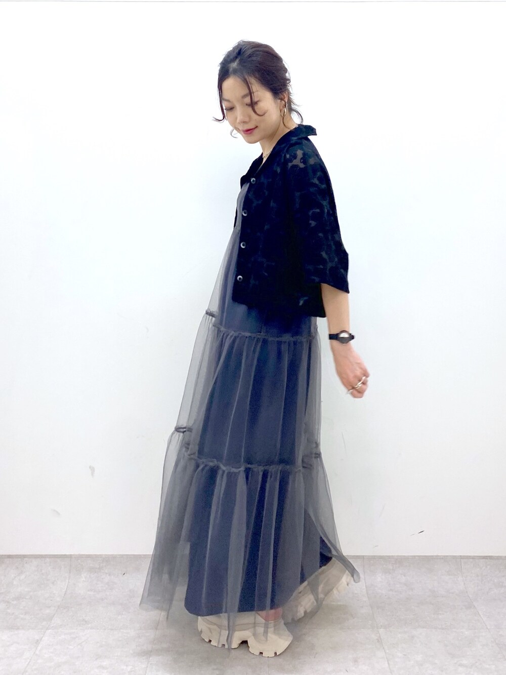 グレー系のワンピース、ブラック系のシャツ/ブラウス、ホワイト系のサンダルを着用したレディースの夏コーディネートの2枚目の写真