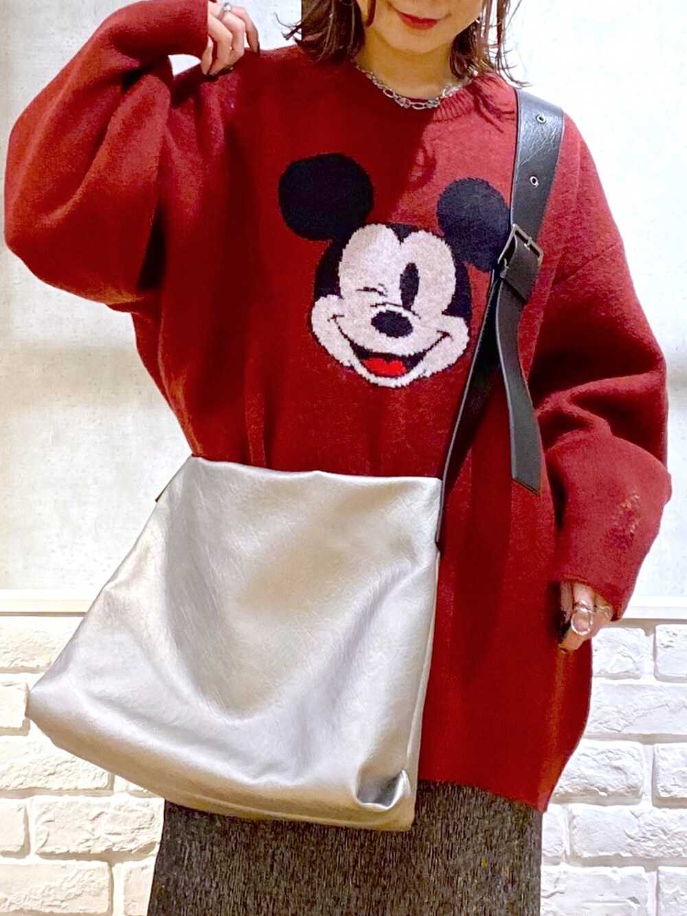 ブラック系のスカート、ブラック系のブーツ、シルバー系のトートバッグを着用したレディースの冬コーディネートの2枚目の写真